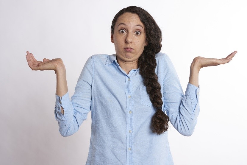 Femme qui hausse les épaule et a les main vers le ciel