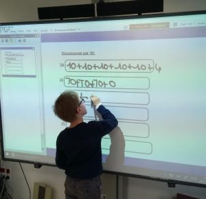 Un enfant travaille sur un tableau numérique à l'IEM